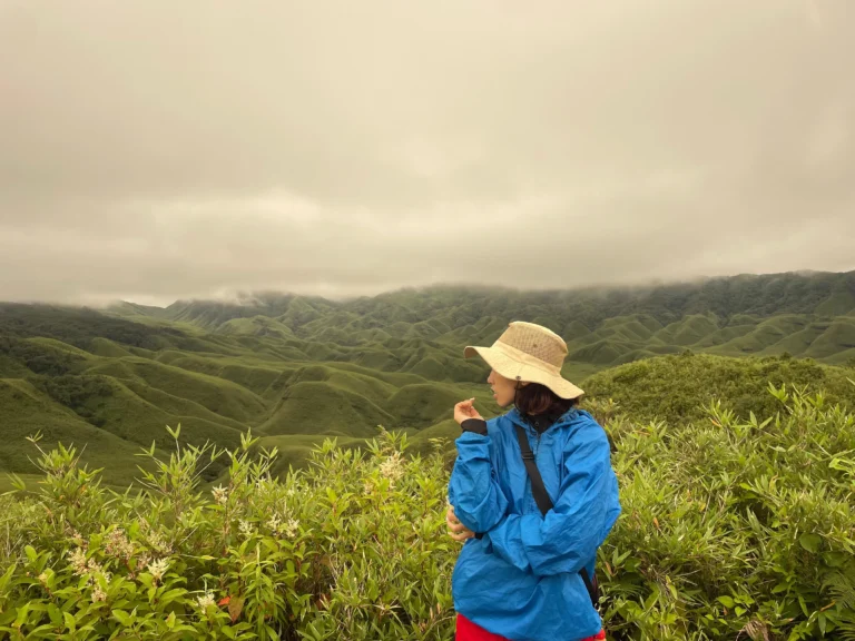 A girl enjoying the scenic green hills of Dzukou Valley