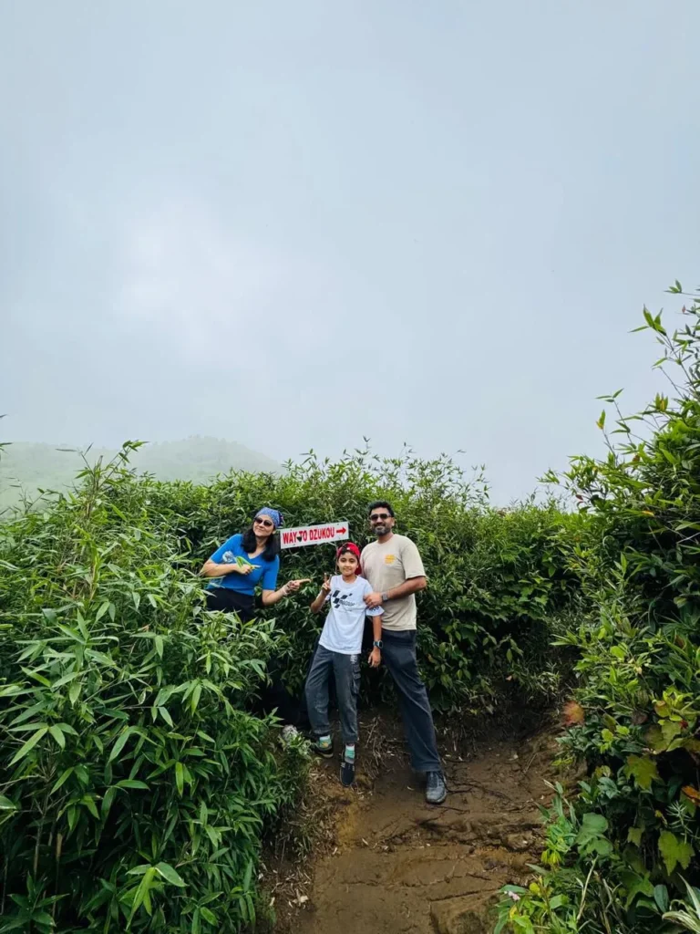 Family at Dzukou Valley trail sign