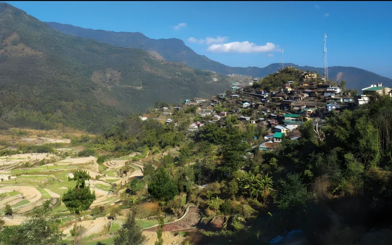Khonoma village on a hillside with terraced fields and surrounding mountains