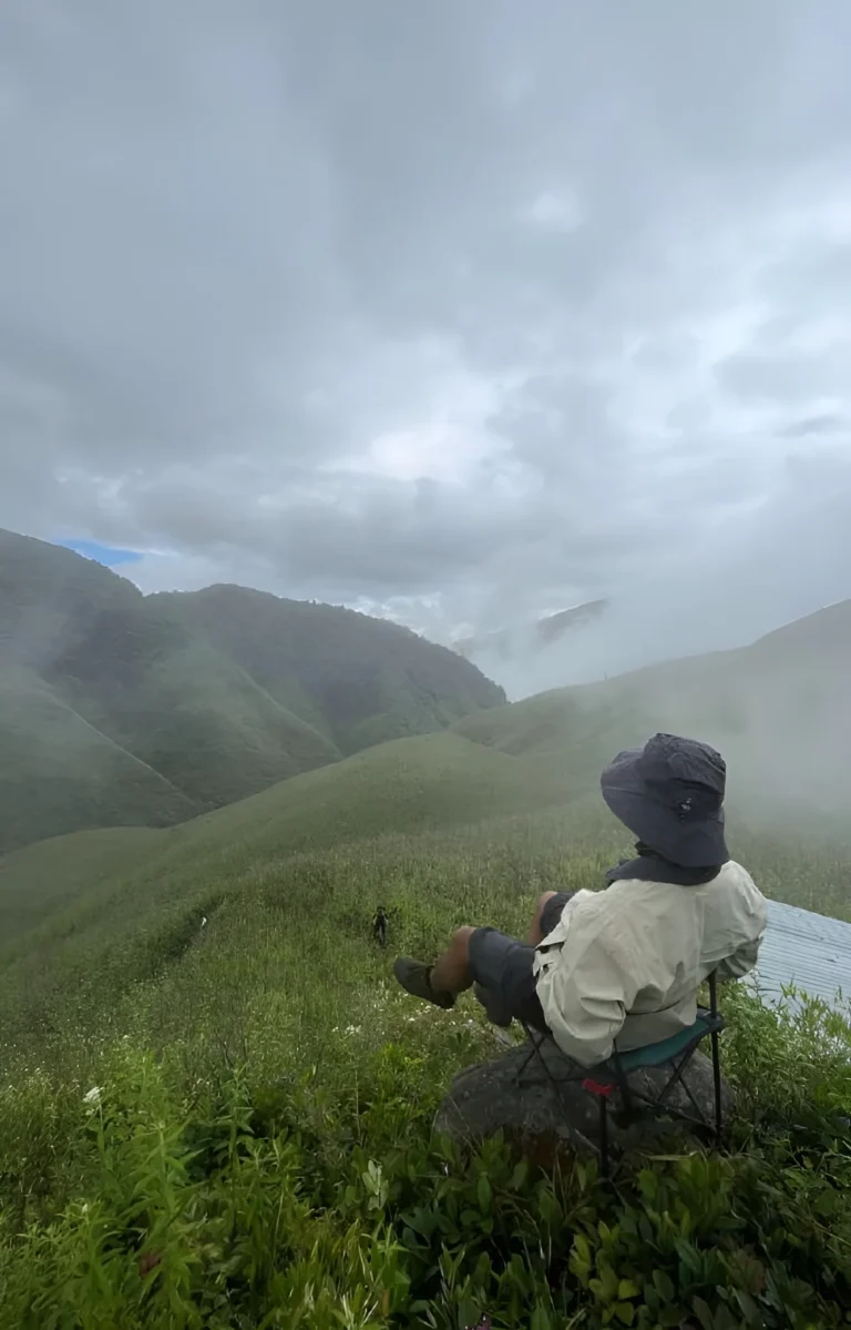 Man relaxing on a chair in Dzukou Valley hills